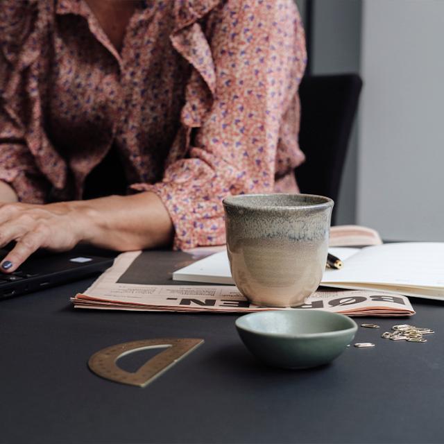 god firmakaffe i keramik kop ved kvinde