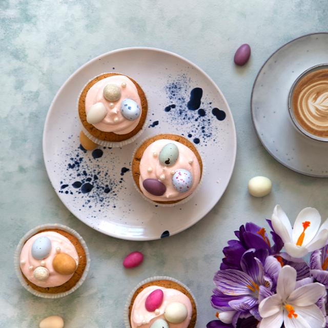 påskemuffins klar til servering med kaffe og flødeost frosting