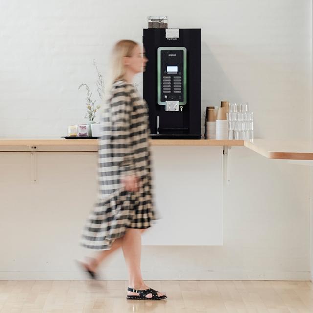 kvinde går forbi animo kaffemaskine på arbejdet