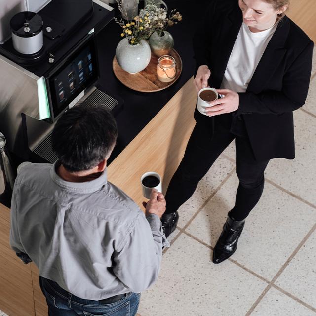 to medarbejdere hos agro food park taler sammen ved kaffemaskinen 