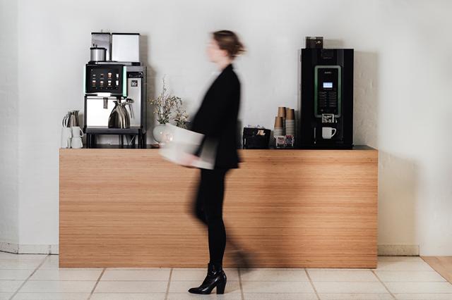 kvinde går forbi BKI kaffeløsningen i virksomheden